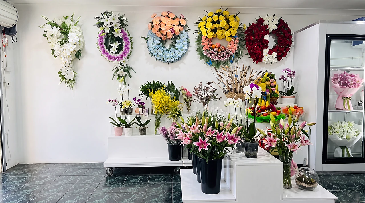 Inside the shop: the wreath wall, potted orchids and buckets of pink lilies