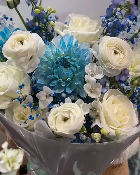 White ranunculus and roses with a blue dahlia and baby’s breath