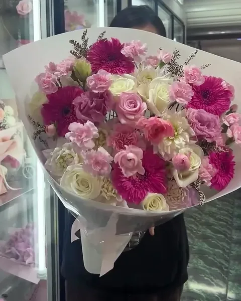 Pink roses and ranunculus together in pink wrap